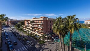 A multi-story hotel with balconies, a parking lot, and a view of the ocean. - Amazing Home with terrace & view Sorrento Center (Sorrento)