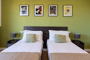 A double room with two beds, green walls, and four framed artworks above the beds. - Amazing Home with terrace & view Sorrento Center (Sorrento)