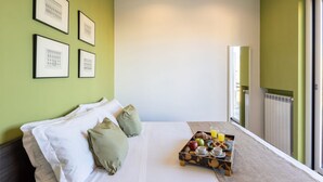 Ein Hotelzimmer mit einem Bett, einem Frühstücksbrett und gerahmten Bildern an der Wand.