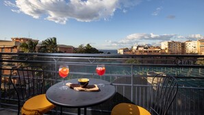 A balcony with a table, two chairs, and two drinks. - Amazing Home with terrace & view Sorrento Center (Sorrento)
