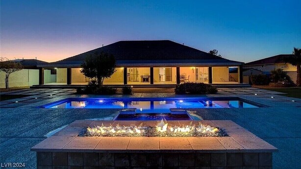 Una casa moderna con piscina y una chimenea en primer plano.