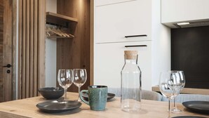 Comedor con una mesa de madera dispuesta para cuatro personas, incluyendo platos, tazones y vasos.