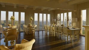 A spacious dining area with a high ceiling, large windows offering a view of the countryside, and a chandelier. - Exclusive, luxurious Villa. Unique location near Certaldo (Certaldo)