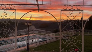 A gazebo with ornate metalwork and a view of a pool area during sunset. - Exclusive, luxurious Villa. Unique location near Certaldo (Certaldo)