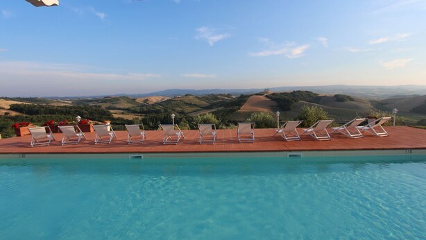 A poolside area with lounge chairs and a view of rolling hills. - Exclusive, luxurious Villa. Unique location near Certaldo (Certaldo)
