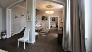 A spacious living area with a staircase, a white sofa, and a dining table. - Exclusive, luxurious Villa. Unique location near Certaldo (Certaldo)