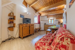 Relax in a warm and inviting space with a comfortable sofa, TV, and dining area.