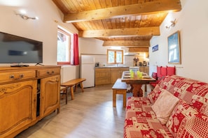 Relax in this inviting living space with a flat-screen TV, dining table, and comfortable sofa.
