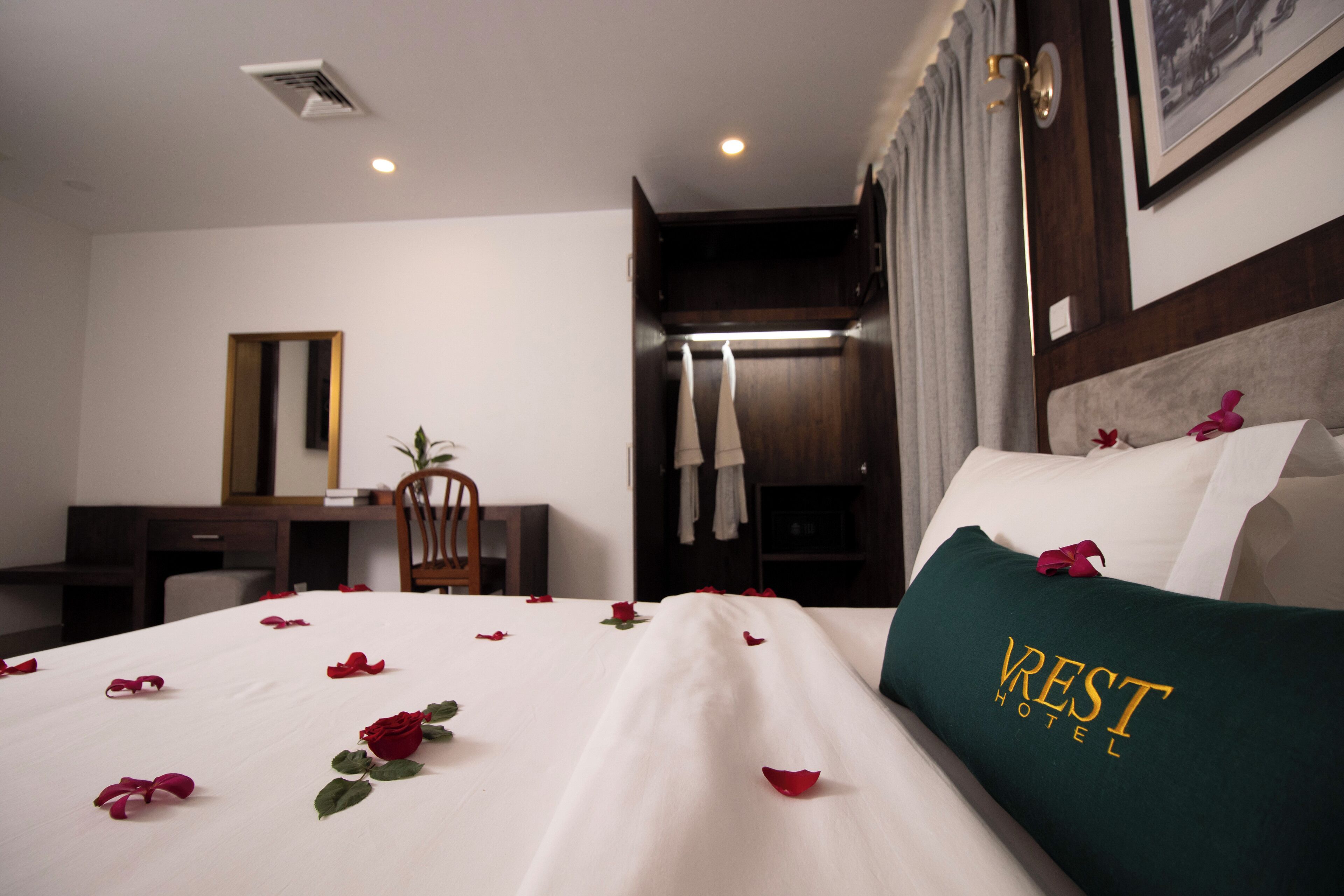 A hotel room with a neatly made bed, a desk, and a chair.
