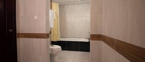 Un baño con inodoro, lavamanos y zona de ducha.