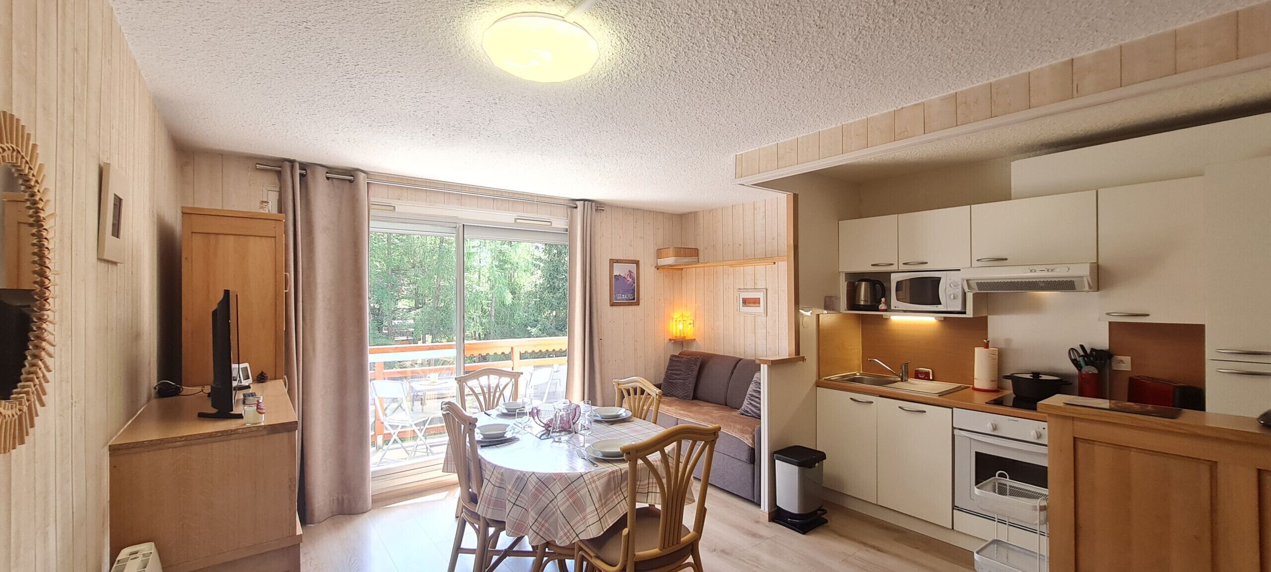 A compact kitchen with wooden cabinets, a microwave, and a sink.