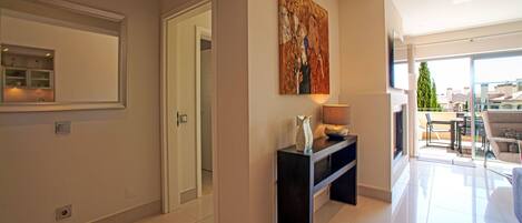 A modern interior with a hallway leading to a balcony.