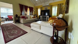 Una sala de estar con un sofá, un televisor, una mesa de centro y un globo decorativo.