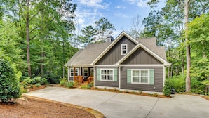 A two-story house with a front porch, a garage, and a well-maintained yard with trees and shrubs. - 4 Mi to Ski Sapphire! Lakefront Cabin w/ Dock (Sapphire)