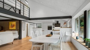 Un interior moderno con comedor, cocina y un espacio tipo loft.