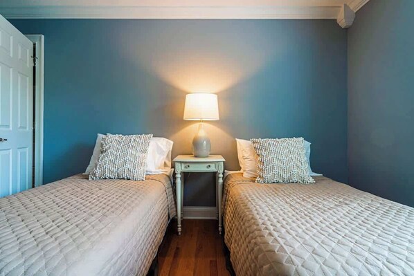 A room with two beds, a nightstand with a lamp, and a door. - Waterfront Access | Lake Views | Dock | Pool Table (Estill Springs)