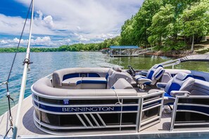 A Bennington pontoon boat with a covered seating area, a steering wheel, and a canopy. - Waterfront Access | Lake Views | Dock | Pool Table (Estill Springs)