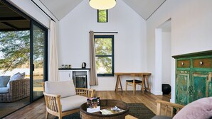 Een moderne woonkamer met een groot raam, een eethoek en een groen kastje.