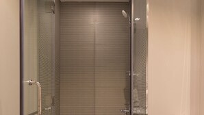 A modern bathroom with a glass-enclosed shower, a white sink, and a toilet. - Modern 1BR in Business Bay (Dubai)