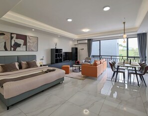 Relax in a spacious room with a large bed, sofa, and dining area, plus a balcony with outdoor views.