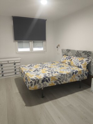 Tabla de planchar con plancha y ropa de cama