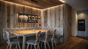 Un comedor con paneles de madera, una mesa larga, cuatro sillas y un banco.