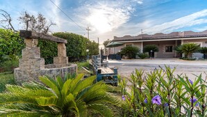 A residential area with a stone structure, a parked cart, and a house with a tiled roof. - Apartment 'Casula Salento' with Private Garden, Wi-Fi and Air Conditioning (matino)