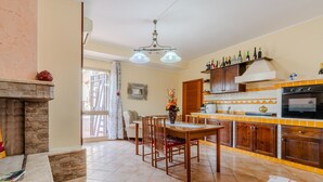 A kitchen with a dining area, a fireplace, and a tiled floor. - Apartment 'Casula Salento' with Private Garden, Wi-Fi and Air Conditioning (matino)