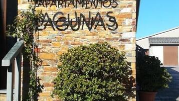 A stone building with a sign reading 'Apartamentos Laguna 3'.