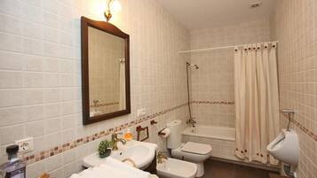 Ein Badezimmer mit Waschbecken, Toilette, Bidet und Badewanne.