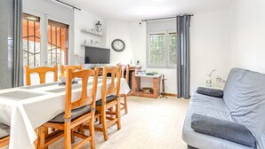 Een eetruimte met een tafel, stoelen en een televisie.