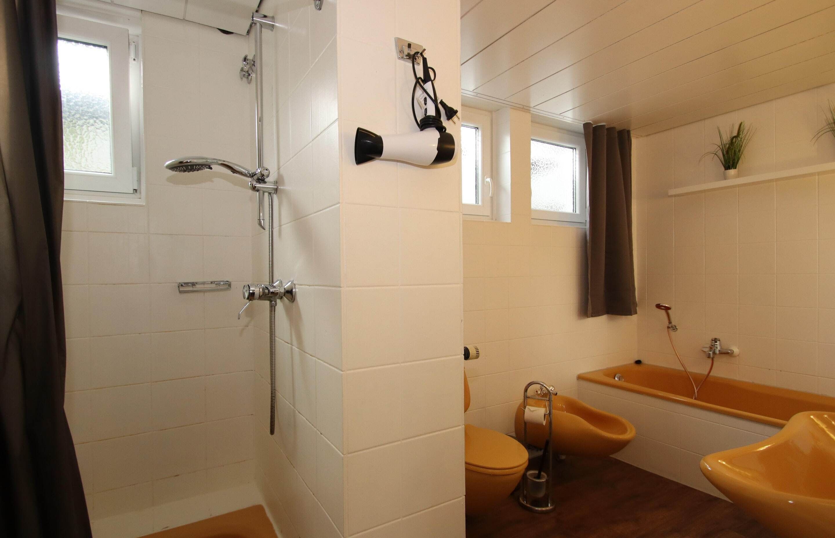 A bathroom with a shower, two sinks, and a bathtub.