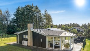 A modern house with a large glass conservatory, a wooden deck, and a swing set in the yard. - "Martina" - 500m from the sea by Interhome (Jerup)