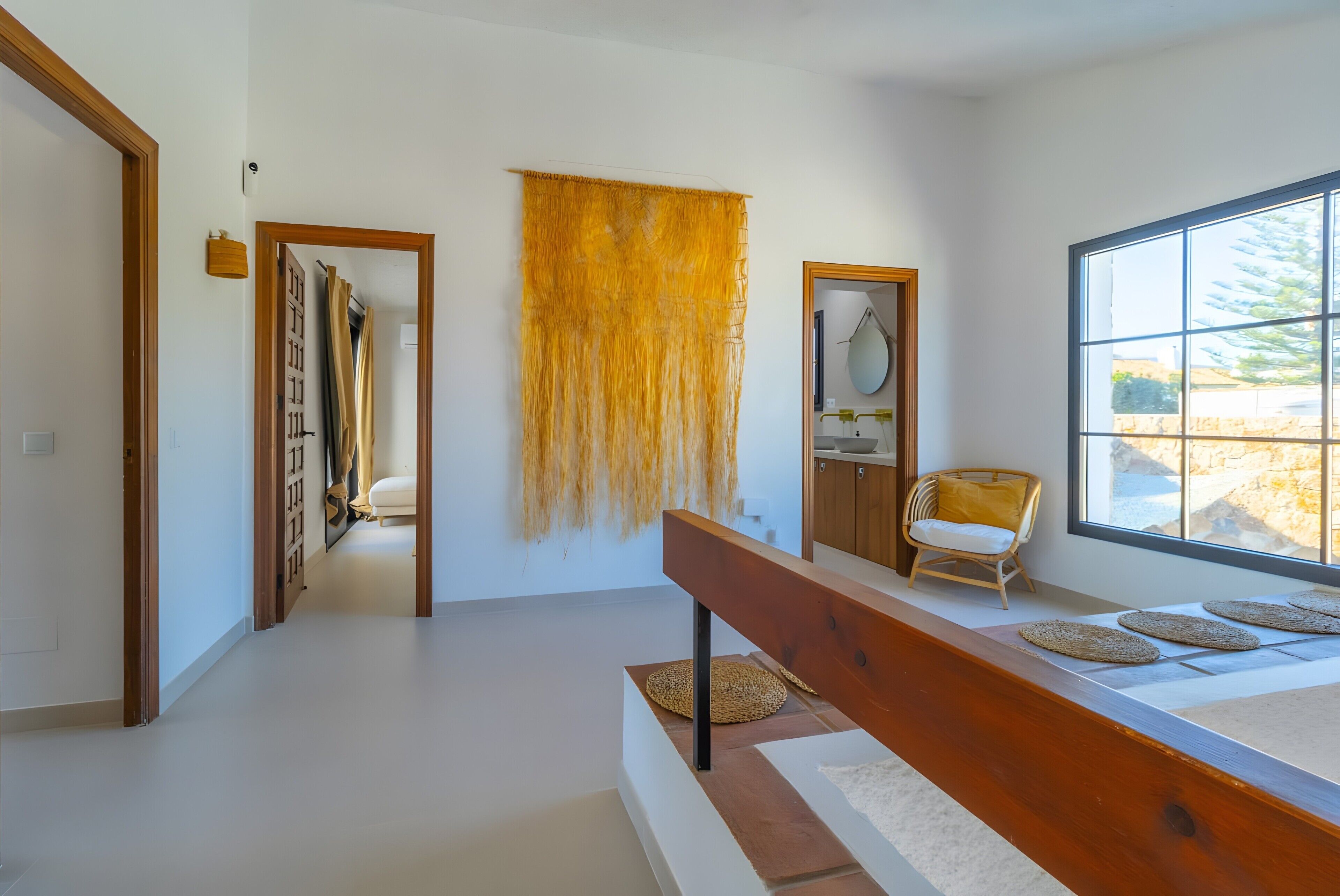 Un interior moderno con un banco de madera, un ventanal y vistas al exterior.
