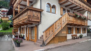 A traditional wooden building with balconies, a staircase, and a bench. - Vajolet Apartment with Mountain View and Balcony (Campitello di Fassa)