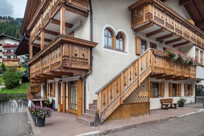 A traditional wooden building with balconies, a staircase, and a bench. - Apartment 'Vajolet' with Mountain View and Balcony (Campitello di Fassa)