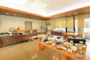 A buffet setup with various food items and a clock on the wall. - Raconter Arima (Kobe)