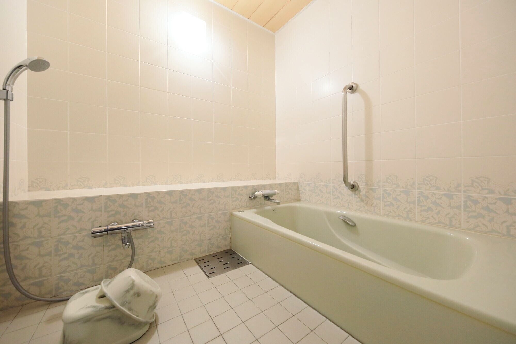 Une salle de bain avec une baignoire, une douche et des toilettes.