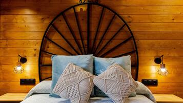 Una cama con cabecera circular, dos lámparas de pared y una pared de madera.