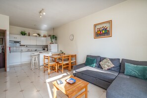 Een modern appartement met keuken, eethoek en woonkamer.