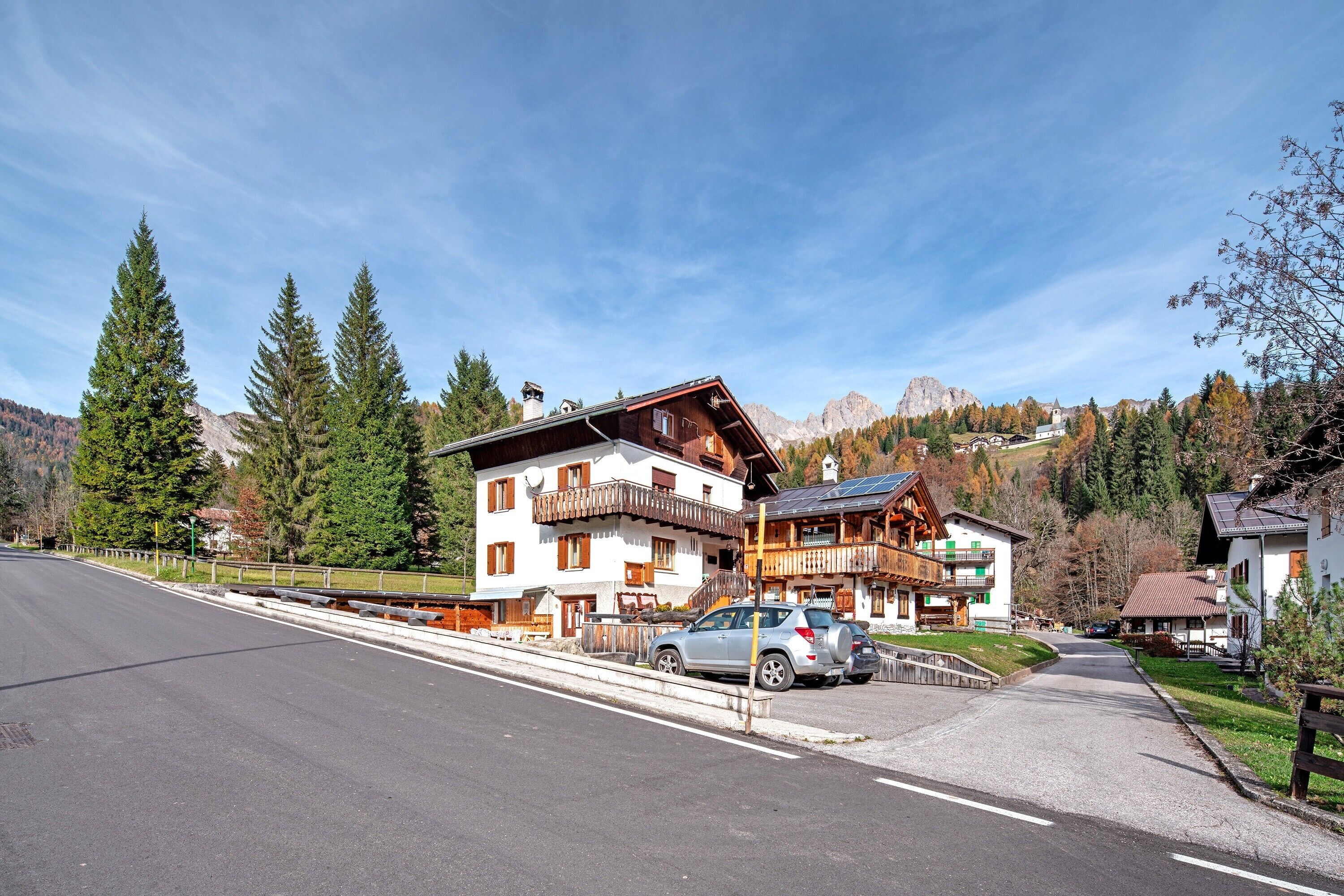 A mountain resort with wooden buildings, a paved road, and a clear sky.