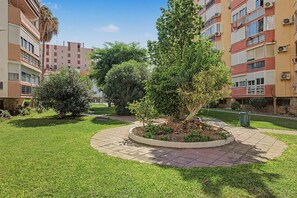 Ein Innenhof mit einem zentralen, kreisförmigen Garten, umgeben von mehrstöckigen Wohngebäuden mit Balkonen.