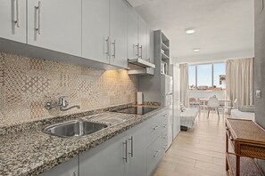 A modern kitchen with granite countertops, stainless steel appliances, and patterned backsplash. - Studio Apartment 'Sol Y Breeze' with Sea View, Wi-Fi and Air Conditioning (Torre del Mar)