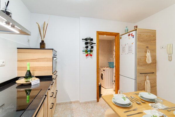 A modern kitchen with a wooden countertop, a wine bottle, and a welcome sign.
