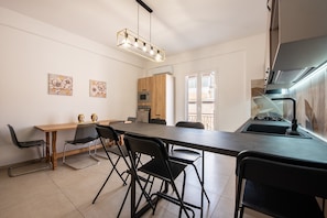 Une cuisine moderne avec une table à manger, des chaises et un four encastré.