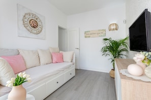 A modern living room with a sofa, a television, a potted plant, and a wall-mounted artwork. - Vacation Apartment 'Martimar Candelaria' with Sea View, Shared Pool and Wi-Fi (Candelaria)