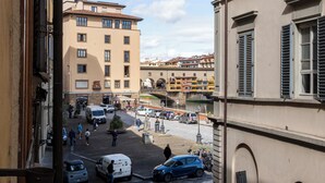 Vista de una calle con edificios, coches aparcados y peatones.
