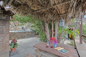 A wooden table with a book, a teapot, and cups, set under a thatched roof structure. - ‘El Pilar’ with Sea Views, Private Pool, and Wi-Fi (La Guancha)