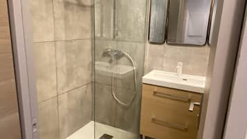 Chuveiro, toalhas de banho, papel higiênico