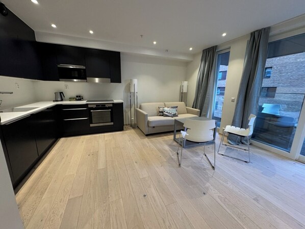 A modern apartment with a kitchen, living area, and large windows.